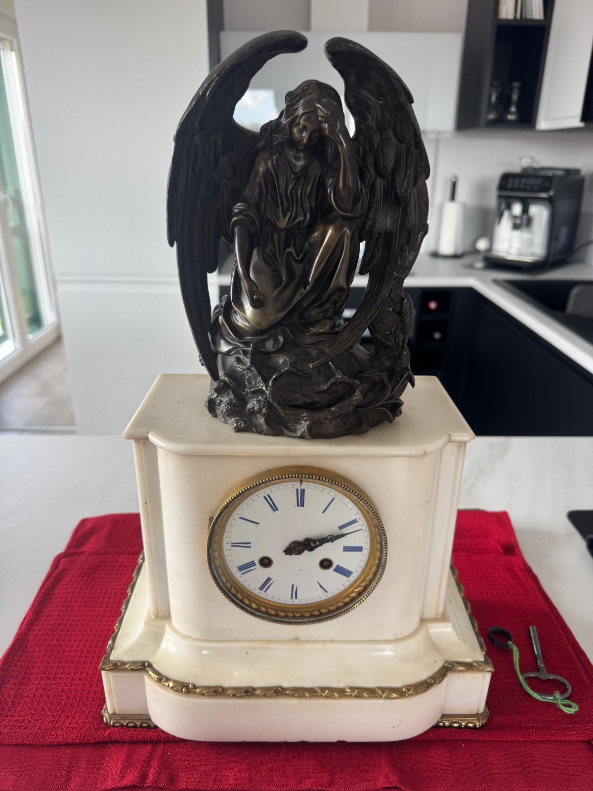 Pendule en marbre blanc surmontée d’un ange en bronze, cadran émaillé à chiffres romains